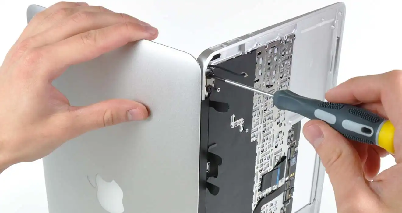 MacBook opened for board-level repair with screwdriver work on internal components