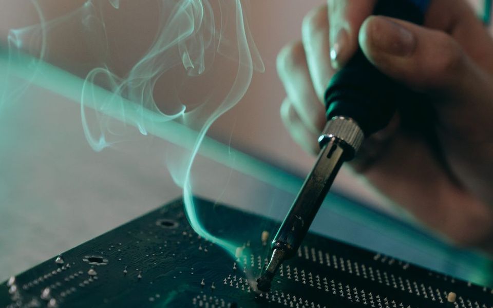 Technician soldering a component on a circuit board