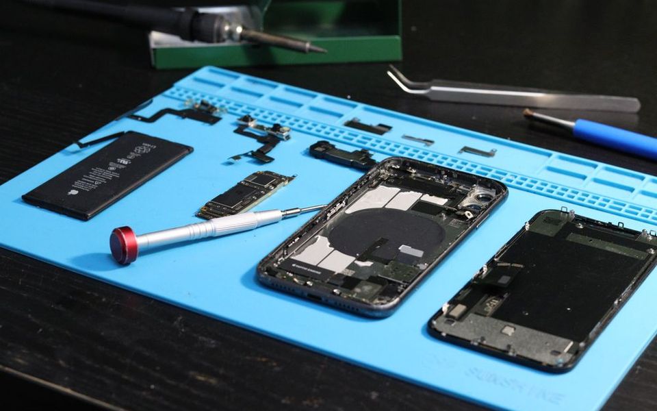 Disassembled smartphone on a repair mat