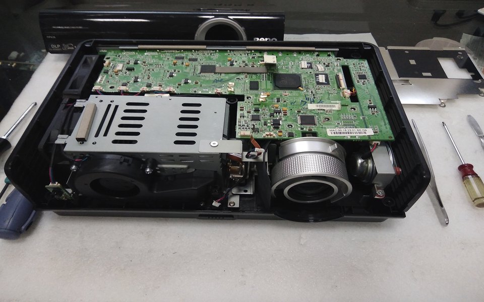 BenQ projector opened on our bench with repair tools