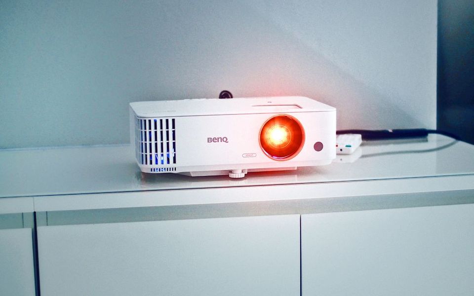 White projector with its lens lit