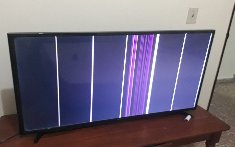 TV screen showing vertical coloured lines from a panel fault